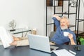 Cheerful mature male employee enjoys morning coffee at the workplace in the office