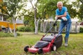 Cheerful mature man with lawnmower on a farm Royalty Free Stock Photo