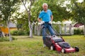 Cheerful mature man with lawnmower on a farm Royalty Free Stock Photo