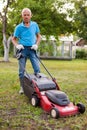 Cheerful mature man with lawnmower on a farm Royalty Free Stock Photo