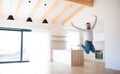Cheerful mature man moving in new unfurnished house, jumping. Royalty Free Stock Photo