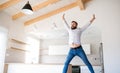 Cheerful mature man moving in new unfurnished house, jumping. Royalty Free Stock Photo