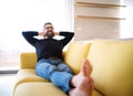 Cheerful mature man sitting on sofa in unfurnished house. Royalty Free Stock Photo