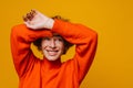 Cheerful mature woman posing with arms raised isolated