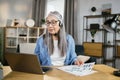 Cheerful mature woman presenting financial report to colleagues through video call on laptop. Royalty Free Stock Photo