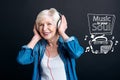 Cheerful mature woman smiling while listening to music