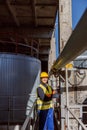 Joyful male engineer standing near metal pipe at factory Royalty Free Stock Photo