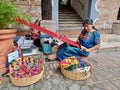 Cheerful mayan indian woman wearing a traditional huipil crafting handmade weavings in the city of Antigua in Guatemala. Royalty Free Stock Photo