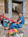 Cheerful mayan indian woman wearing a traditional huipil crafting handmade weavings in the city of Antigua in Guatemala. Royalty Free Stock Photo