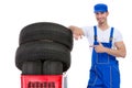 Cheerful mechanic pointing in new tires Royalty Free Stock Photo