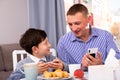 Cheerful man and his son with smartphones Royalty Free Stock Photo