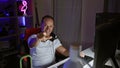 Cheerful middle age man streamer winning the game, pointing with delight in his cozy gaming room Royalty Free Stock Photo