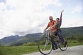 Cheerful Middle aged Couple Bicycling On Country Road
