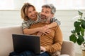 Cheerful Middle Aged Couple Using Laptop Together At Home Royalty Free Stock Photo