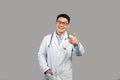 Cheerful middle aged japanese male therapist in white coat and glasses showing thumb up, advice medicine