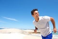 Cheerful middle aged man running on the beach