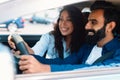 Cheerful middle eastern couple sitting in car together, travelling by auto on weekend, selective focus on smiling man