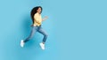 Cheerful Middle Eastern Woman Running In Mid Air, Blue Background Royalty Free Stock Photo