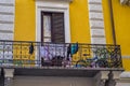 Cheerful, Milanese yellow building with balcony, drying clothes and kids bicycle.