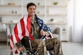 Cheerful military guy in wheelchair with flag of the US Royalty Free Stock Photo