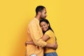 Cheerful millennial african american family in casual hugging, enjoy tender romantic moment