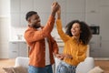 Cheerful millennial black spouses having fun together dancing in kitchen Royalty Free Stock Photo