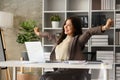 Cheerful millennial businesswoman relaxing in comfortable office chair and stretching her arms Royalty Free Stock Photo