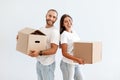 Cheerful millennial couple carrying cardboard boxes, packing stuff for relocation Royalty Free Stock Photo