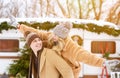 Cheerful millennial couple having fun outside at winter camping, woman piggybacking boyfriend