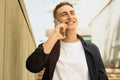 Cheerful millennial european man enjoy lifestyle, calling by smartphone, got good news