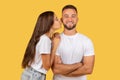 Cheerful millennial european woman in white t-shirt kiss strong man in cheek, enjoy romantic date