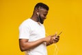 Cheerful millennial guy listening music online on smartphone Royalty Free Stock Photo