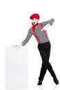 cheerful mime pointing on empty board Royalty Free Stock Photo