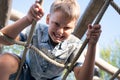 Cheerful and mischievous boy making faces and looking at camera while playing on playground. Royalty Free Stock Photo
