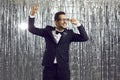 Happy funny young ethnic man in tuxedo suit dancing and having fun at disco party