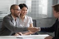 Cheerful mixed race married spouse shaking hands with real estate agent. Royalty Free Stock Photo