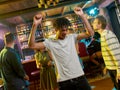 Cheerful mixed race young man having fun, dancing with friends at party in the bar Royalty Free Stock Photo