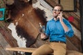 Cheerful model laughing, holding trophy and talking on phone