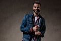 Cheerful model laughing while wearing jeans jacket