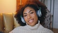 Cheerful model listening headphones portrait. Happy curly woman smiling camera Royalty Free Stock Photo