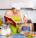 Cheerful mom showing girl recipe of omelette Royalty Free Stock Photo