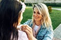 Cheerful mother adjusting daughter`s dress outdoor. Candid happy mom relaxing with her child, enjoying the time together. Mother Royalty Free Stock Photo