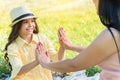 Cheerful mother and daughter clapping hands while relaxing on meadow Royalty Free Stock Photo