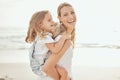 Cheerful mother and daughter having fun at beach. Young mother giving her daughter piggyback ride at beach. Precious Royalty Free Stock Photo