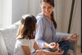 Cheerful mother and daughter sitting in lotus position practice yoga