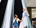 Cheerful Mother And Daughter Standing On Escalator In Shopping Mall Royalty Free Stock Photo