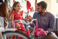 Cheerful mother and father buying new bicycle for little girl in bike shop