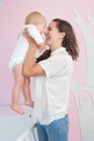 Cheerful mother hugging cute baby at home Royalty Free Stock Photo