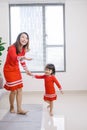 Cheerful mother little daughter standing in living room at home moving dancing to favourite song together