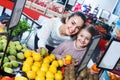 Cheerful mother and little girl choosing fresh fruits Royalty Free Stock Photo